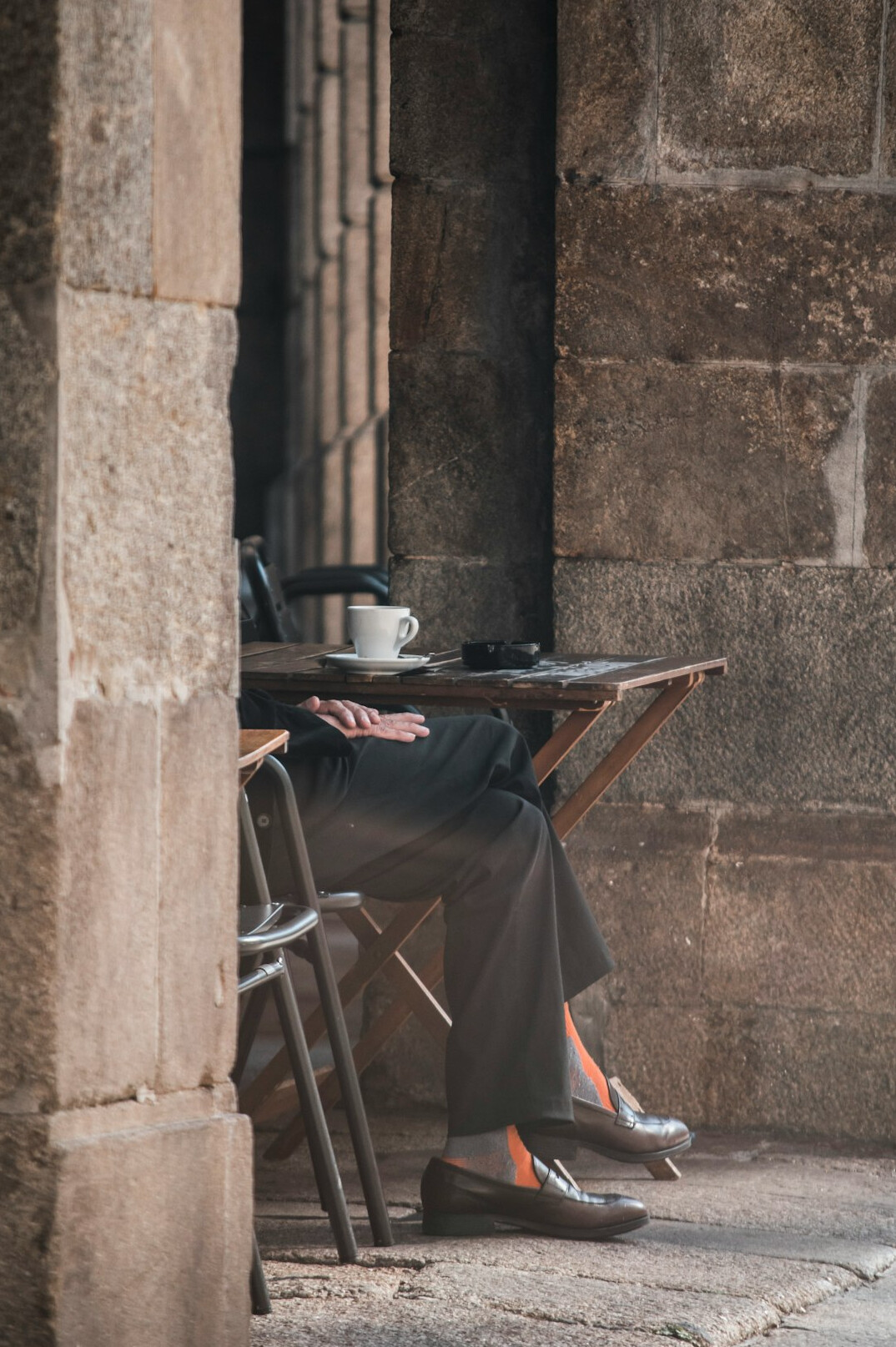 Person writing content on a laptop at a cafe table