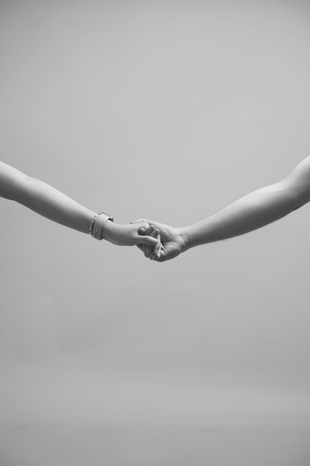 Two business people shaking hands over a table